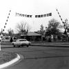 Andrews University alumni leave campus after 1968 homecoming weekend by passing under a sign that reads, 'Cheerio Alumni', at the gate