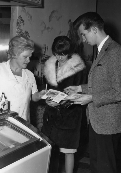 [Warren Jarrard and Jarine Sample passing out ingathering brochures to a local shop employee]