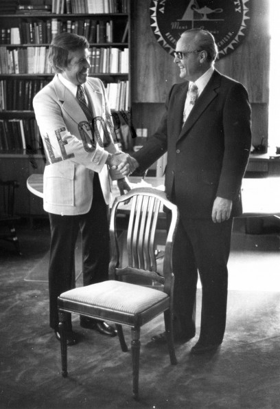 [Donald Prior and H. H. Hill with a chair designed by John Harvey Kellogg]