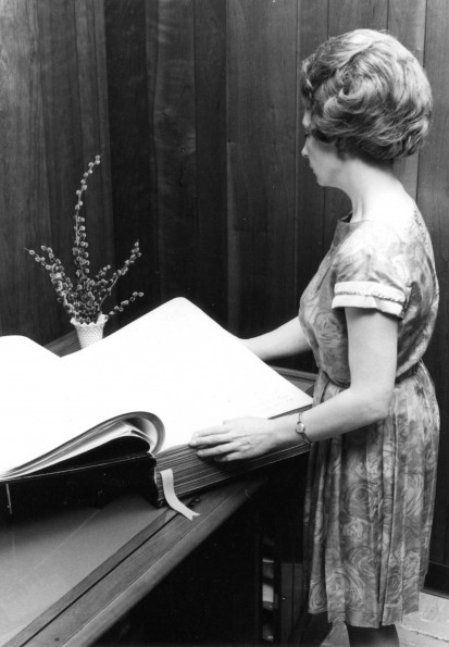 [Louise Dederen looking at a handwritten Bible by young people from the Southern African Division of the Seventh-day Adventist Church in the Andrews University Heritage Room]