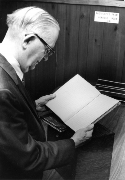 [Emmett Vande Vere reading one of the Pitcairn log books in the Andrews Univeristy Heritage Room]