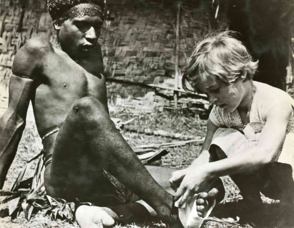 [Unknown child aiding a man in an unknown country]