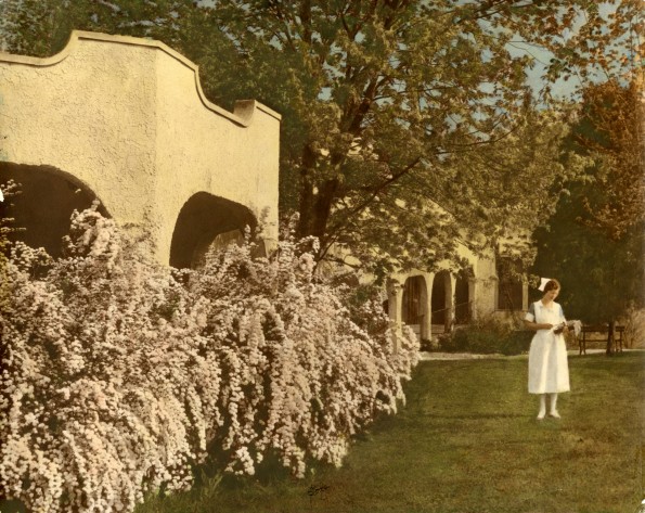 [Florence E. Wheeler standing in front of the Madison Rural Sanitarium and Hospital]