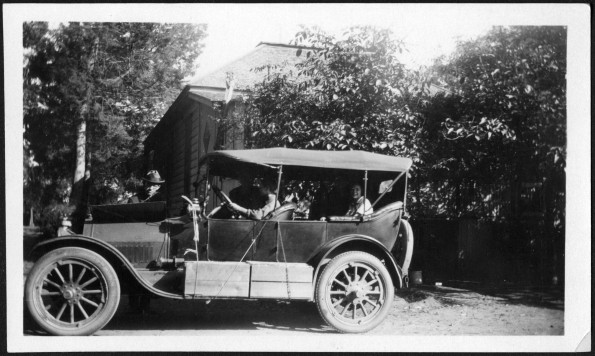 [Uriah Wilton Smith working on his Ford Model T Touring car, probably preparing for a journey]