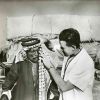 [Unknown doctor aiding a man in an unknown country]