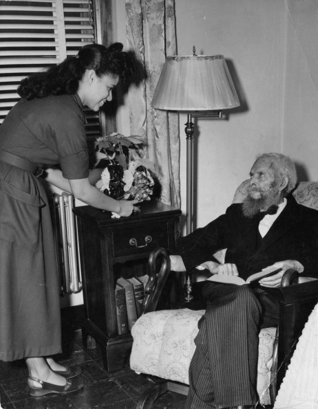 [Vivian L. Moody assisting Charles M. Kinney in his room at the Riverside Sanitarium]