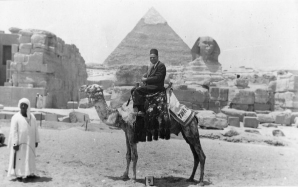 [Louis B. Reynolds riding a camel in front of the Great Sphinx and Pyramid of Khafre in Giza, Egypt]