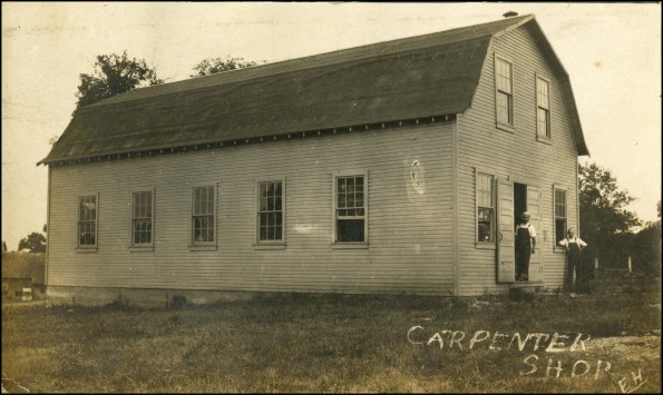 Two unknown men in front of the Madison College carpenter shop
