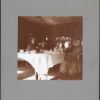 Bessie DeGraw sitting at a breakfast table with an unknown group of people