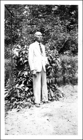 Edward Gates posing in front of tropical foliage