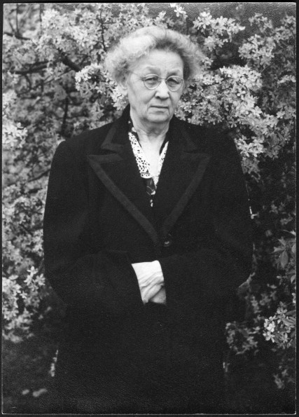 Bessie DeGraw Sutherland posing in front of a tree