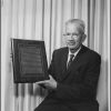 Dr. Joseph E. Sutherland holds a plaque called "The Oath of Hippocrates"