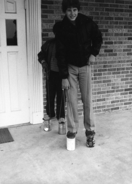 Students playing with can-stilts at the West Memphis Seventh-day Adventist Elementary School